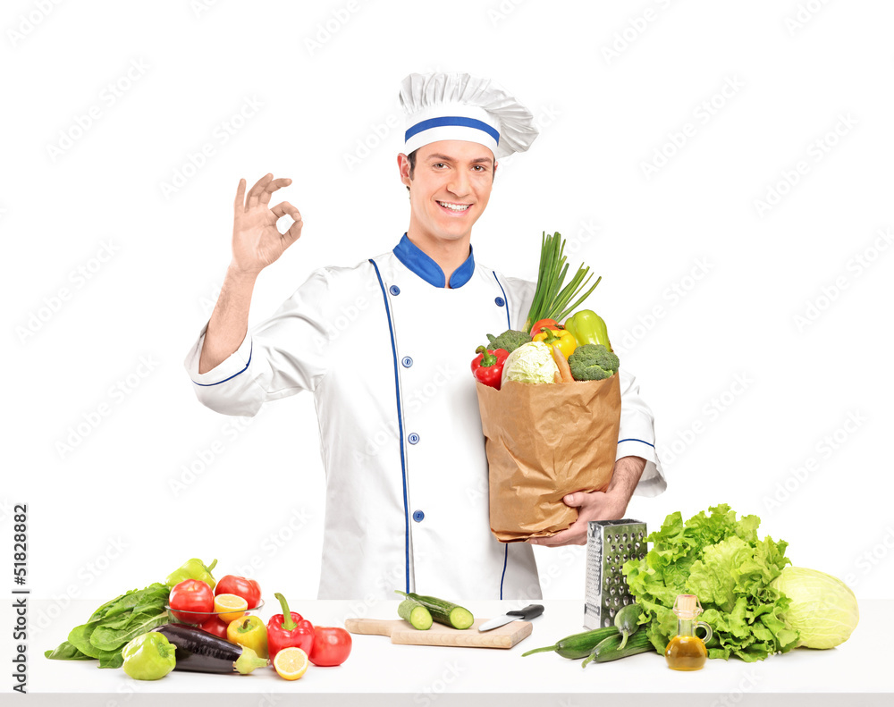 Male chef holding a bag full of healthy vegetable ingridients ne Male chef holding a bag full of healthy vegetable ingridients ne