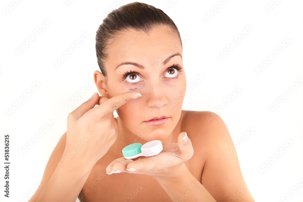 woman inserting a contact lens in her eye woman inserting a contact lens in her eye