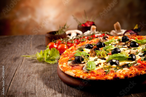 Fotografia Delicious fresh pizza served on wooden table