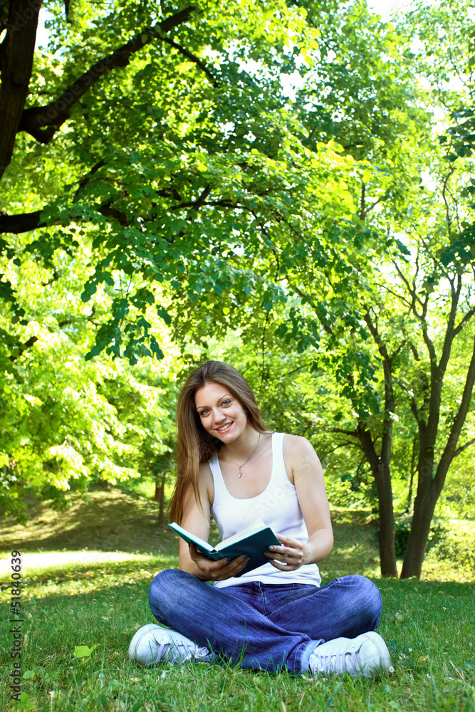 Young woman in green park, book and reading Young woman in green park, book and reading