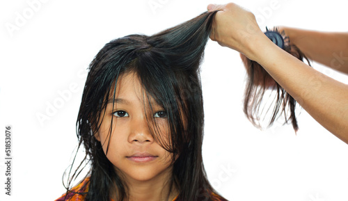 A young Malay/ Asian girl getting her hair dried by mother.