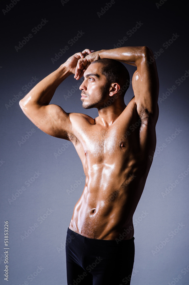 Muscular man in dark studio Muscular man in dark studio