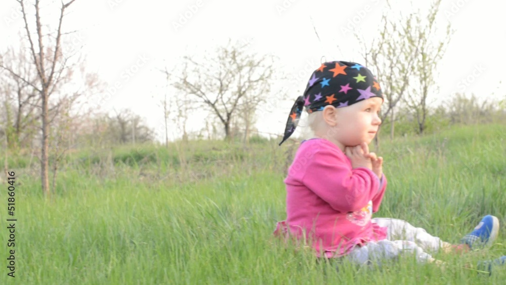 Baby sits on a grass, dolly shot Baby sits on a grass, dolly shot