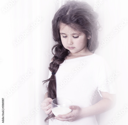 beautiful little girl with a cup of milk. close-up