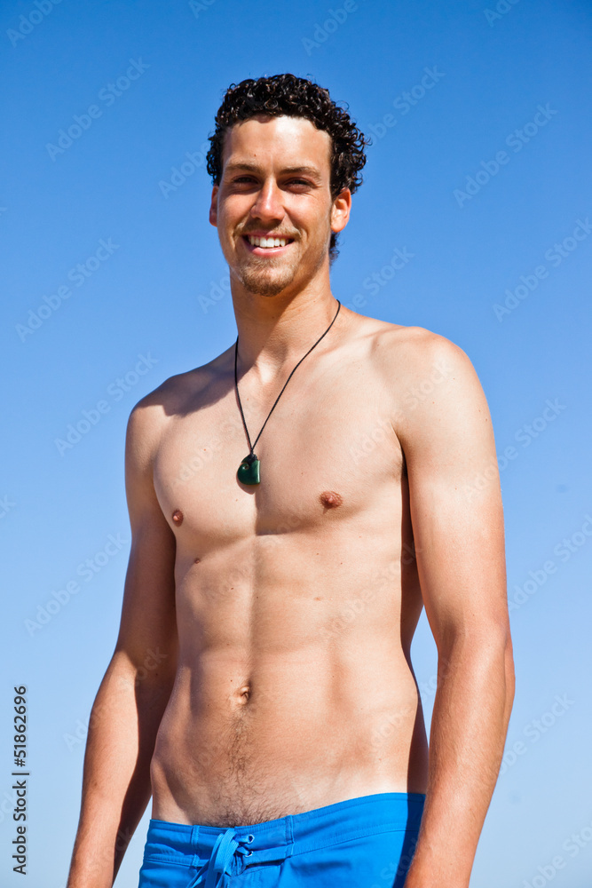 Fototapeta premium Handsome fit young man wearing a blue bathing suit