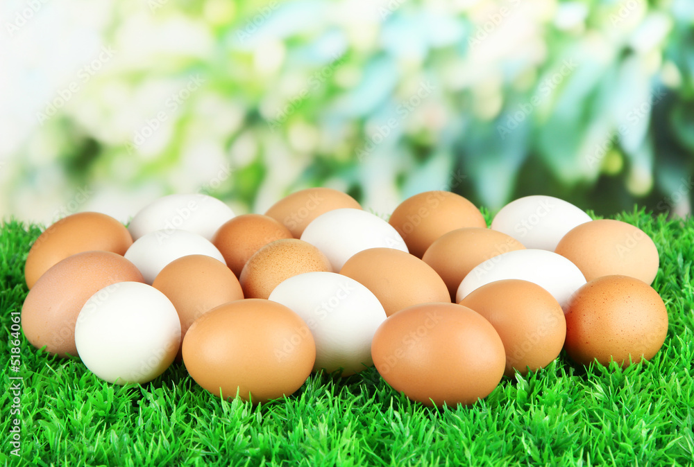 Many eggs on grass on bright background Many eggs on grass on bright background