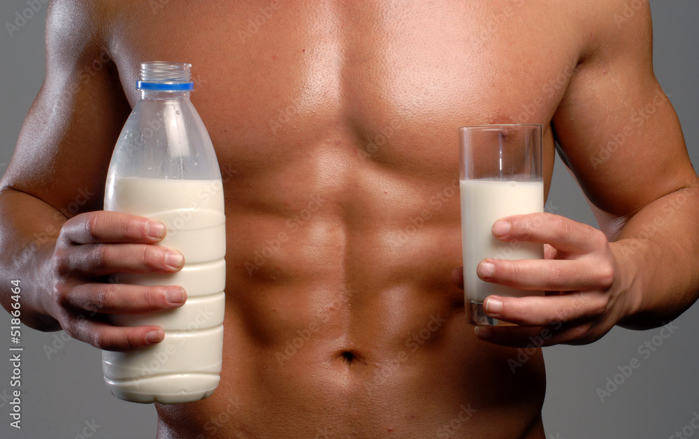 Hombre sano y musculoso sujetando botella y vaso de leche. Hombre sano y musculoso sujetando botella y vaso de leche.