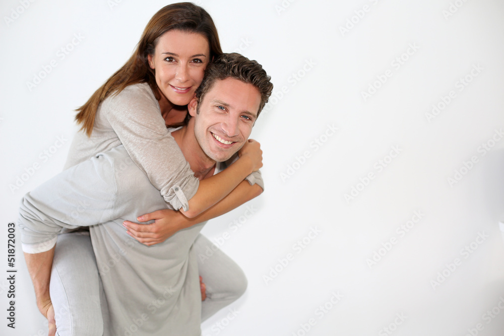 Handsome guy giving piggyback ride to girlfriend Handsome guy giving piggyback ride to girlfriend
