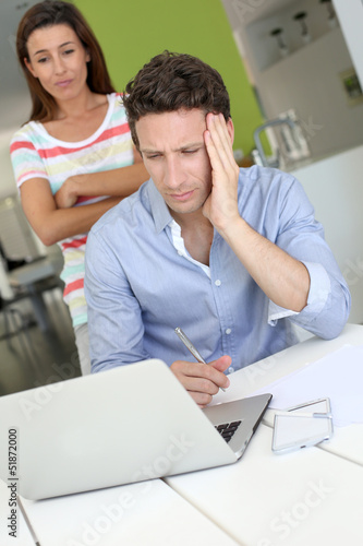 Couple looking at laptop with perplexed expression