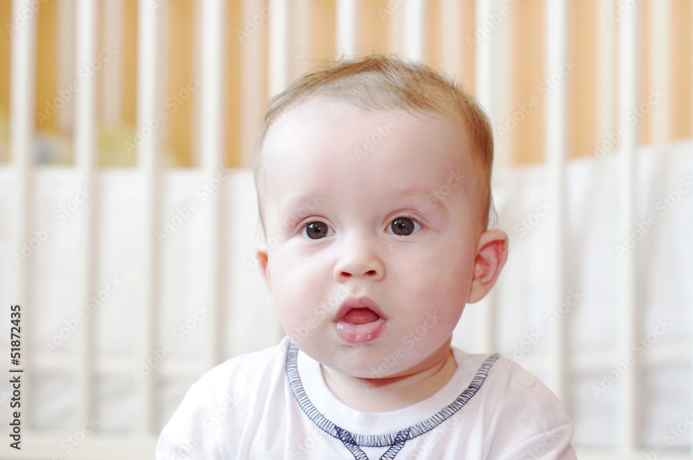 sad baby against white bed