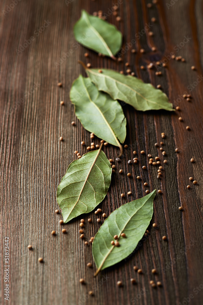 Bay leaves and mustard seeds on wooden background Bay leaves and mustard seeds on wooden background