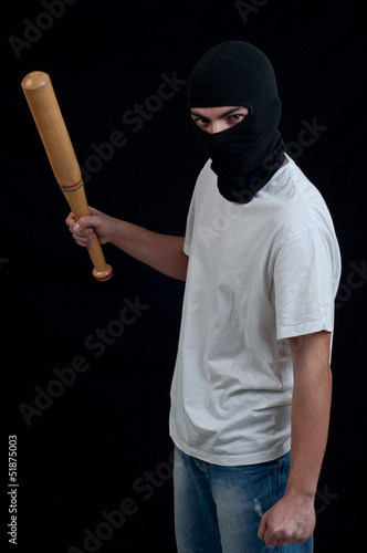 Masked man preparing to attack with bat