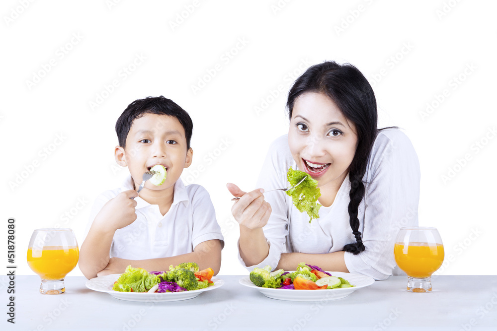 Mother and son eating healthy salad - isolated Mother and son eating healthy salad - isolated