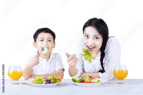 Mother and son eating healthy salad - isolated