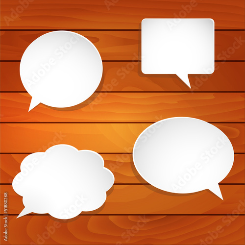 Blank empty white speech bubbles on wooden background