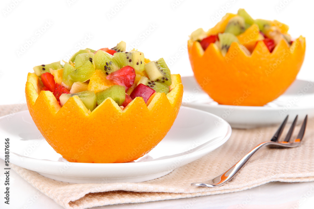 Fruit salad in hollowed-out orange isolated on white