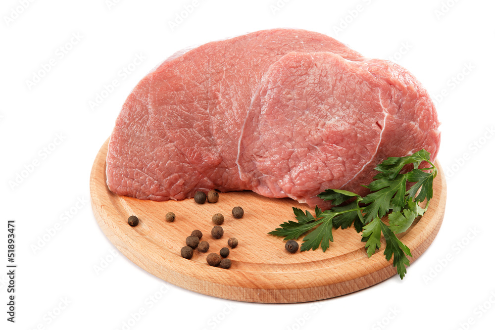 Raw meat on a wooden cutting board isolated on white background. Raw meat on a wooden cutting board isolated on white background.