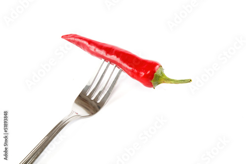 Red hot chili pepper impaled on the steel fork isolated on white © trotzolga