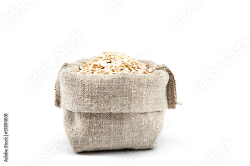 Rolled oats in a canvas bag isolated on white background.