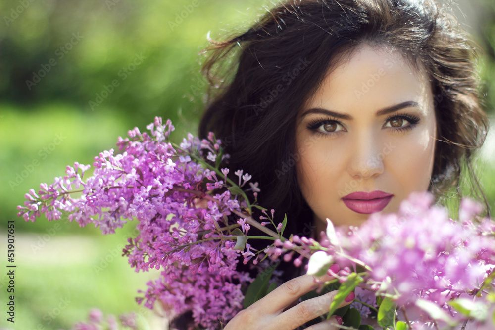 Young brunette woman with lilac flowers, Outdoors portrait Young brunette woman with lilac flowers, Outdoors portrait