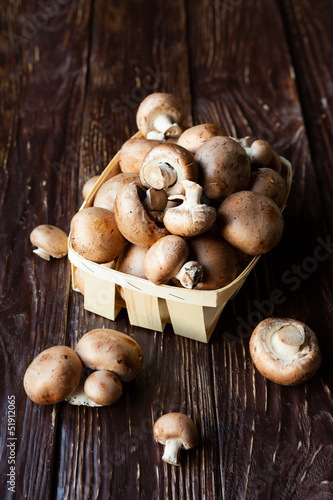 mushrooms in a basket on dark boards photo