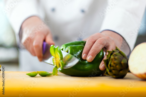 Chef cutting a pepper photo