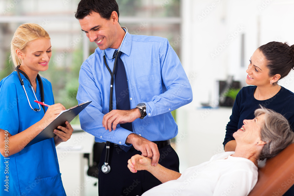 Fototapeta premium doctor and nurse recording senior patient's pulse