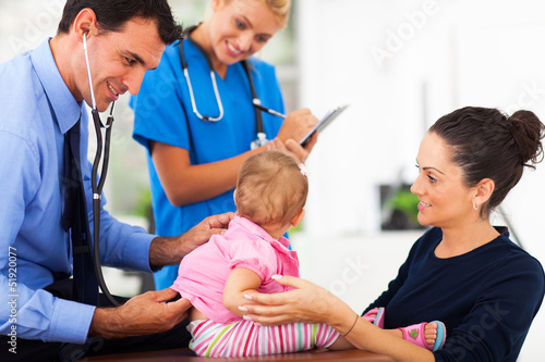 male doctor examining a baby girl