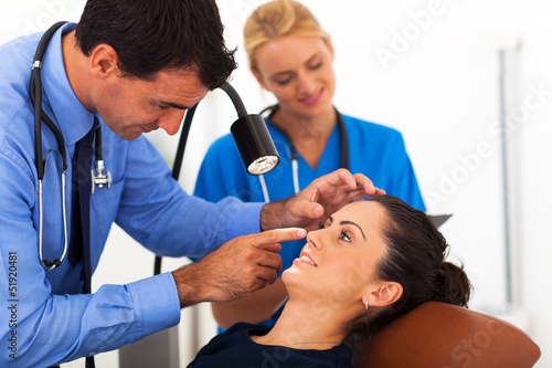 ophthalmologist examining young woman's eye
