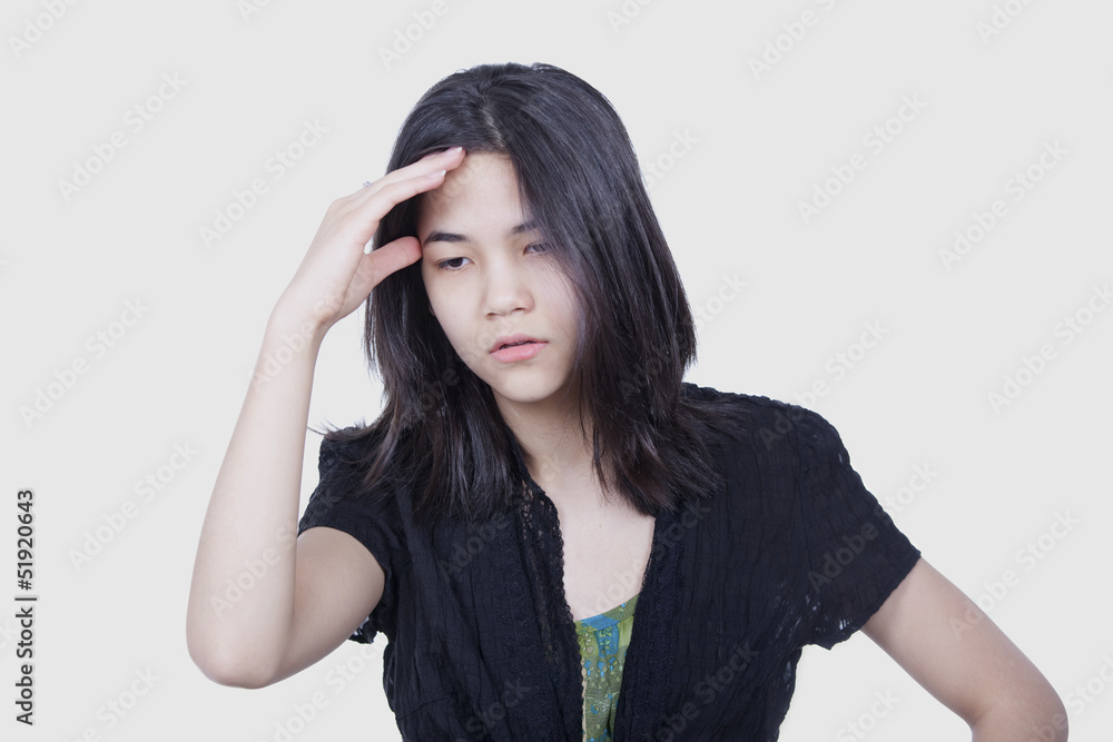 Young biracial teen girl massaging temple, face stressed or havi Young biracial teen girl massaging temple, face stressed or havi