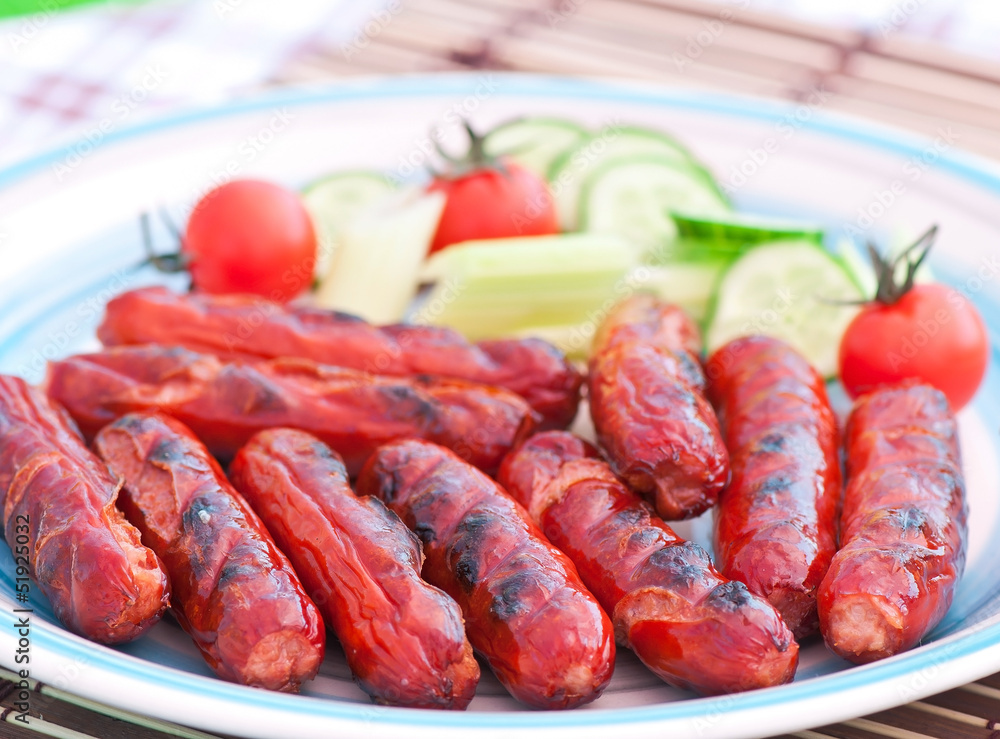 grilled sausages on the grill and a salad of fresh vegetables grilled sausages on the grill and a salad of fresh vegetables