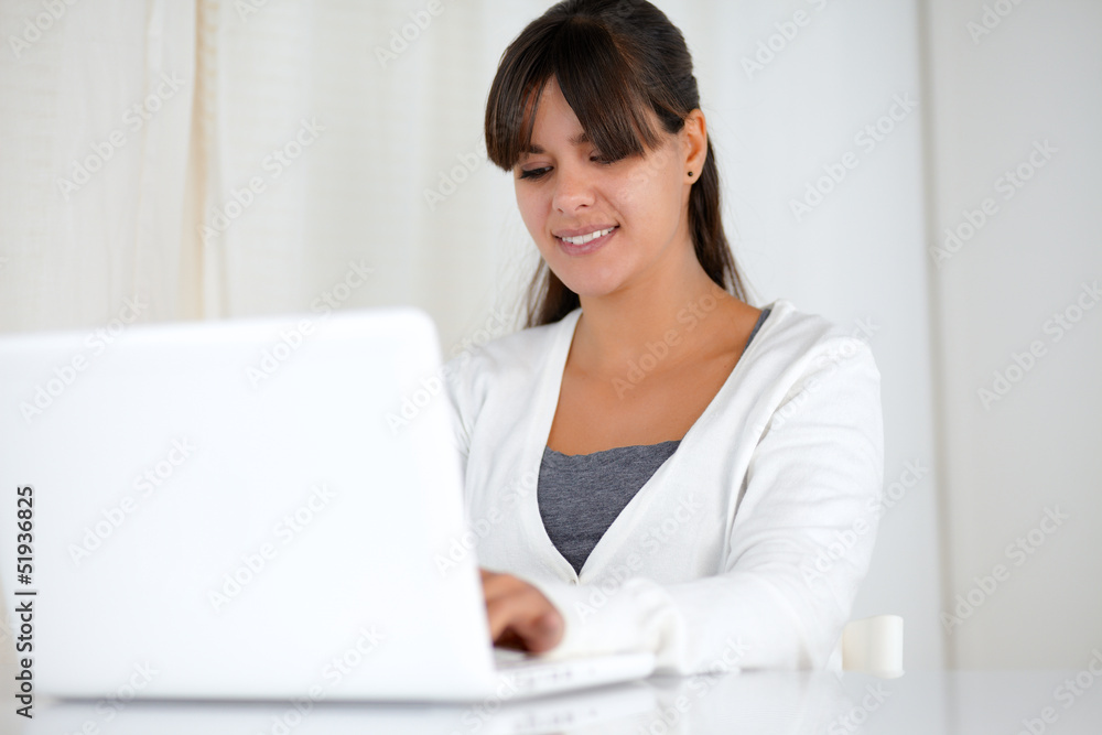 Charming young woman working on laptop computer Charming young woman working on laptop computer