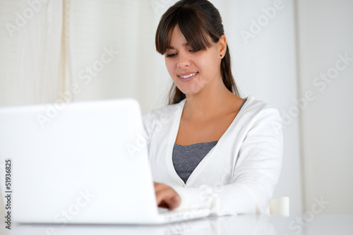 Charming young woman working on laptop computer