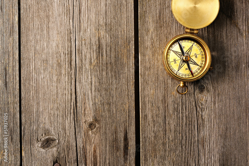 Antique compass over wooden background