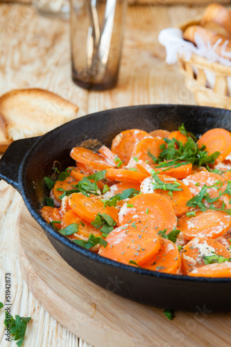 Braised carrots with cream in a pan