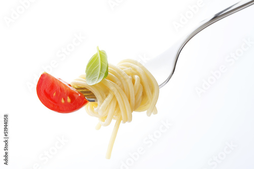 Spaghetti pasta with tomato and basil on fork