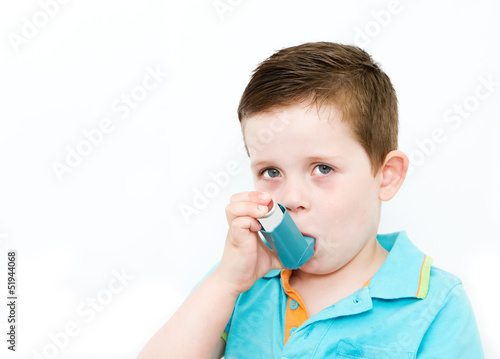 little boy using his asthma pump