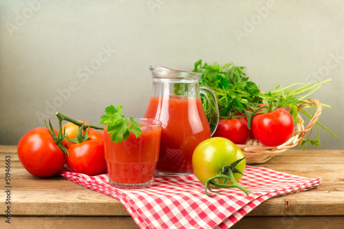 Fresh tomato juice and tomatos on wooden table