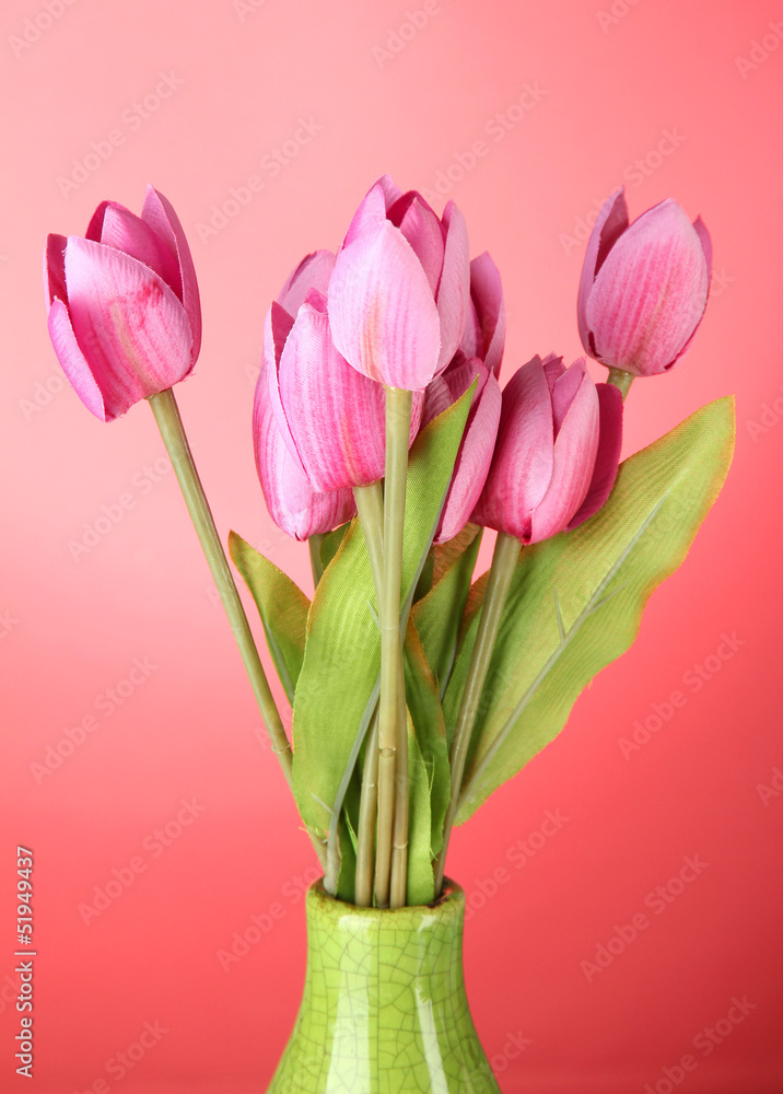 Beautiful bouquet of pink tulips in vase, on red background Beautiful bouquet of pink tulips in vase, on red background