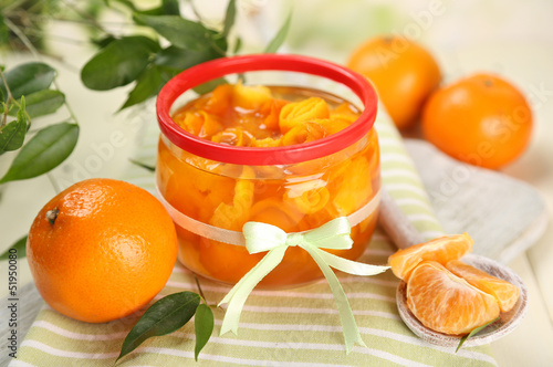 Orange jam with zest and tangerines, on white wooden table