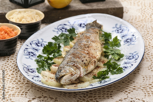 Fototapeta Naklejka Na Ścianę i Meble -  Fish plate in greek tavern. Roasted trout on onion.