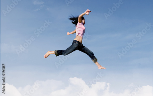 Happy girl jump over clouds