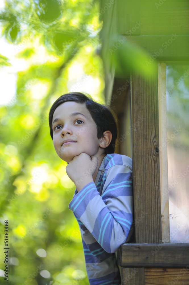 Enfant observant la nature dans sa cabane Enfant observant la nature dans sa cabane