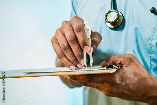 Doctor Using Calipers To Measure EKG