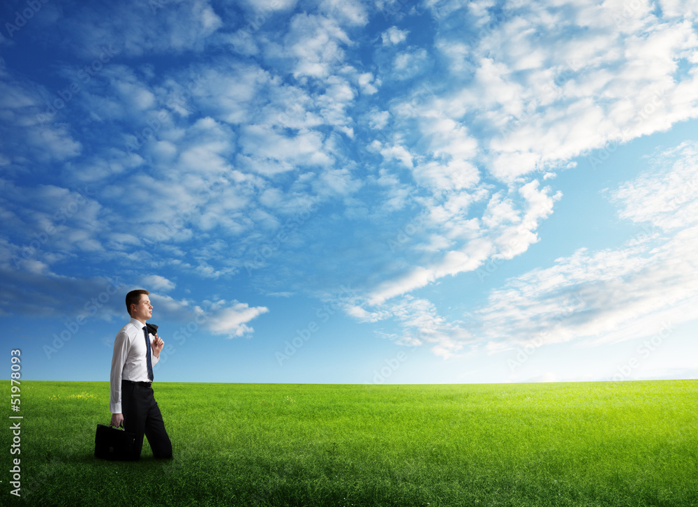 young business man wolking at the field of grass young business man wolking at the field of grass