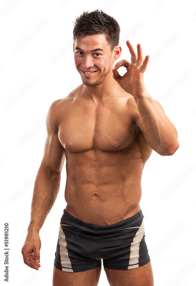 Muscular young man showing the ok sign isolated over white Muscular young man showing the ok sign isolated over white