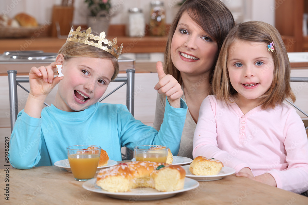 Mother and two daughters eating cake
