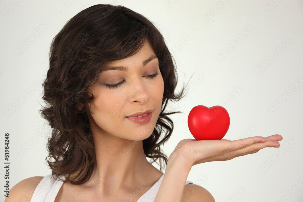 young woman holding a plastic hearth in her hand young woman holding a plastic hearth in her hand