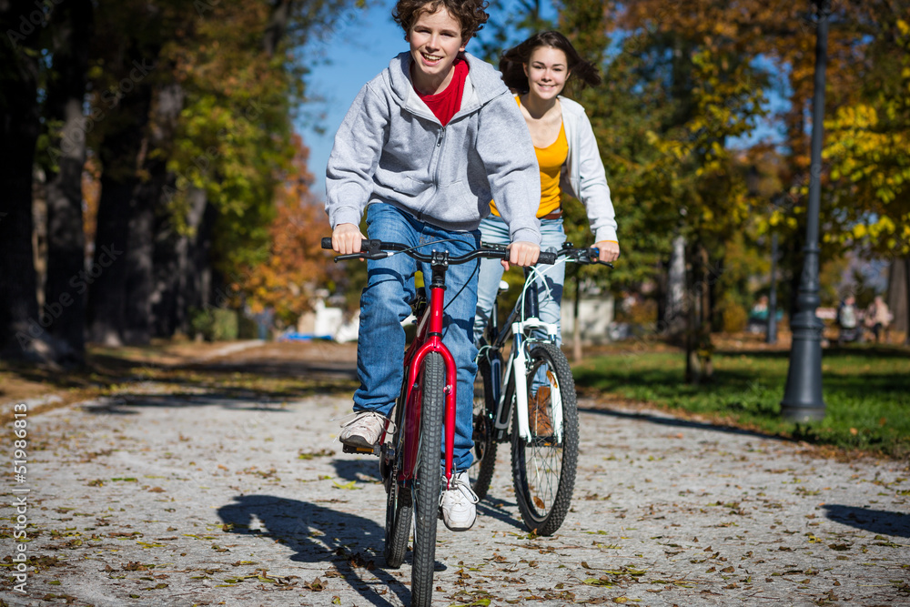 Obraz premium Urban biking - teens riding bikes in city park