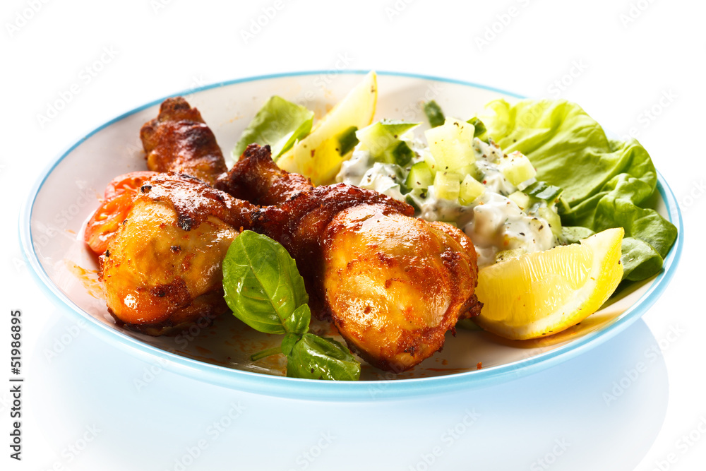 Fototapeta premium Grilled chicken legs and vegetables on white background